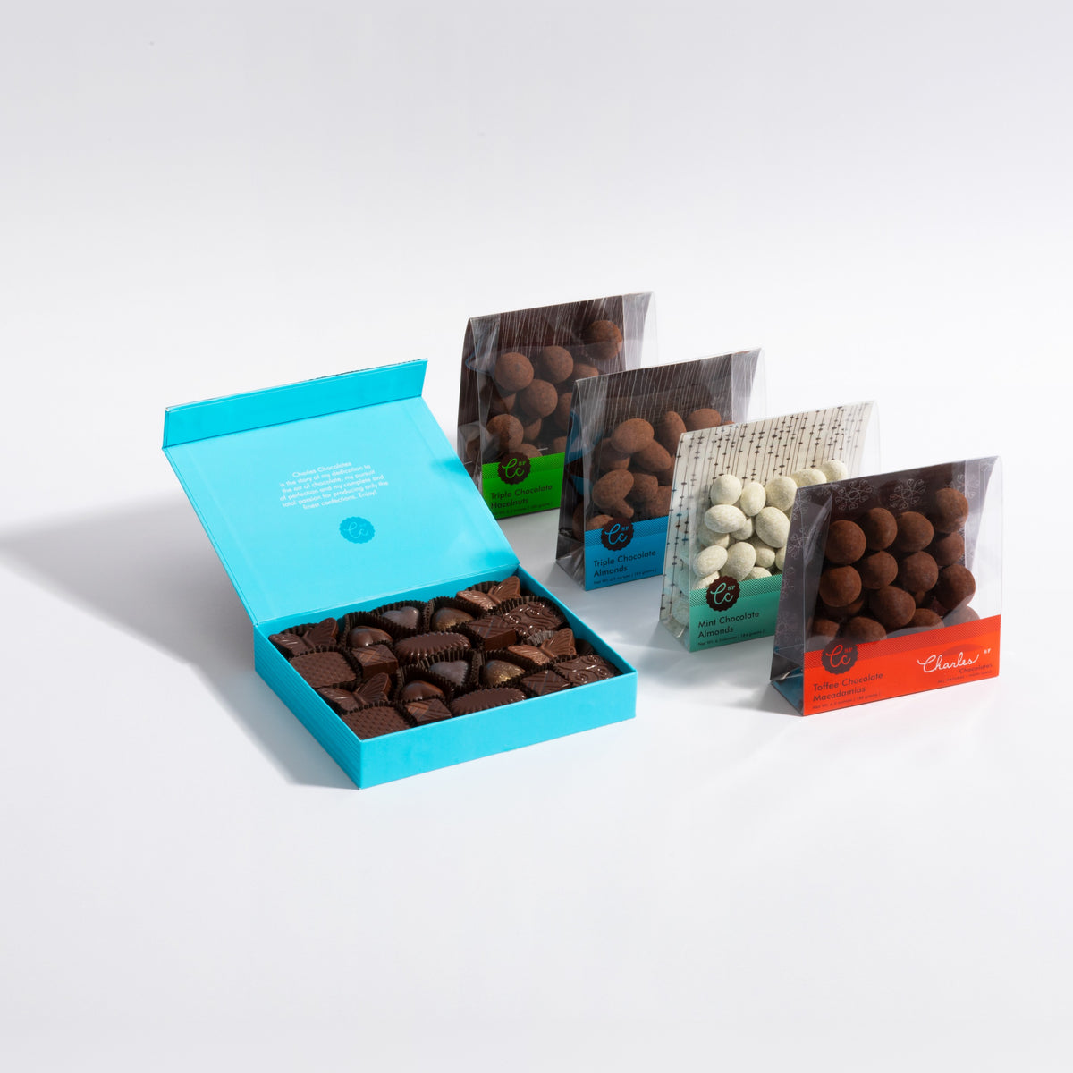 The Classic & Chocolate-Covered Gift Set: the 20 piece Classic Collection box open next to the four chocolate covered nut packs