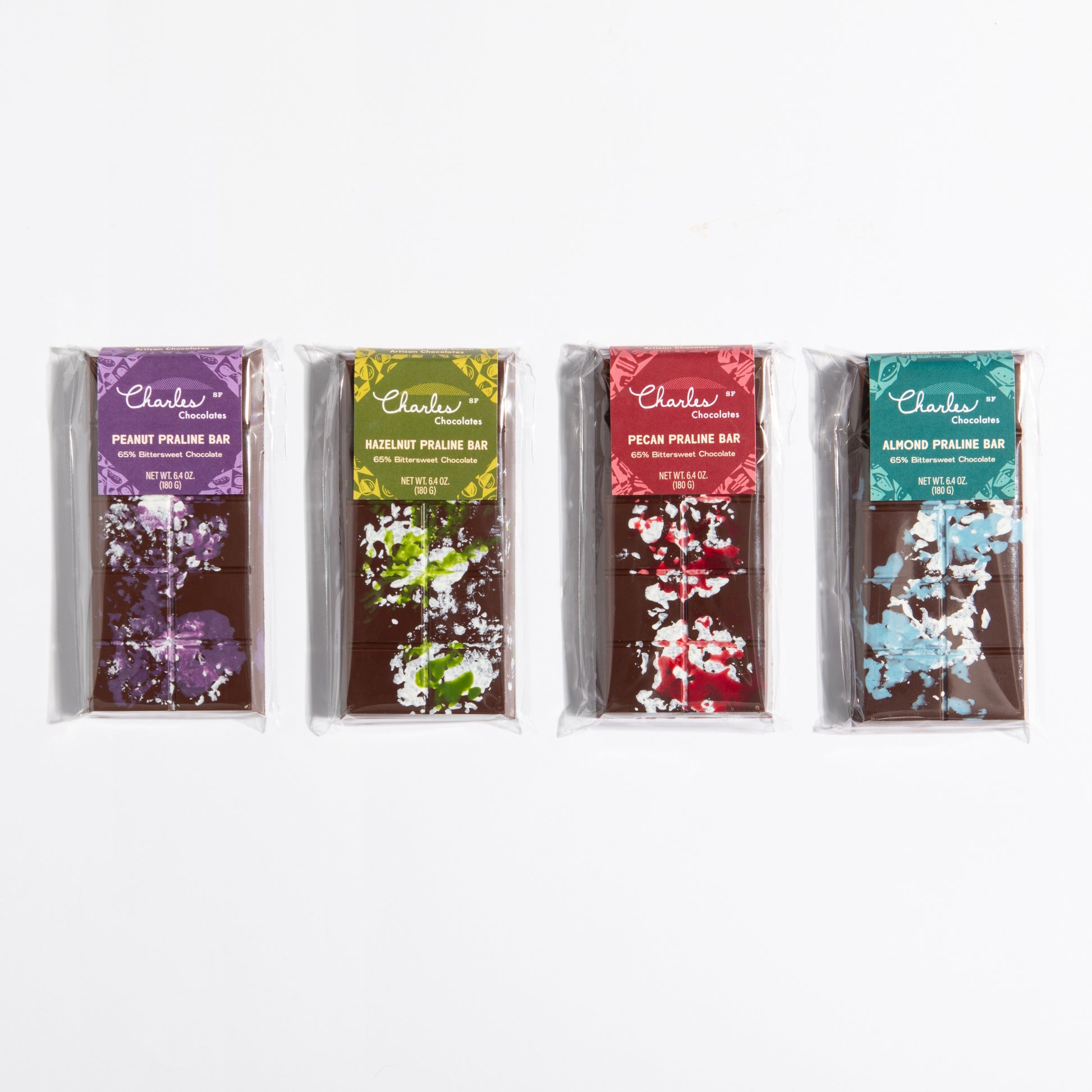 All four French Praline Crunch Bars lined up: almond, hazelnut, peanut and pecan by Charles Chocolates