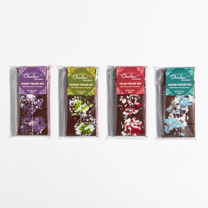 All four Praline Crunch Bars lined up: almond, hazelnut, peanut and pecan by Charles Chocolates