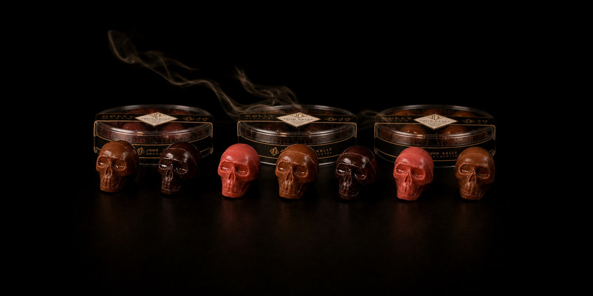 John Kelly Chocolates filled Halloween chocolate skulls in Garnet, Dark and Milk chocolate lined up in front of their boxes