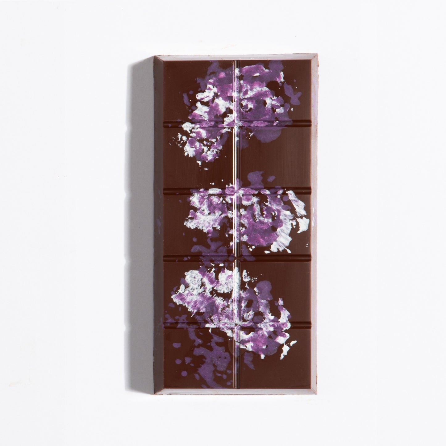 Unwrapped Peanut French Praline Crunch Bar with purple cocoa butter splatter on dark chocolate