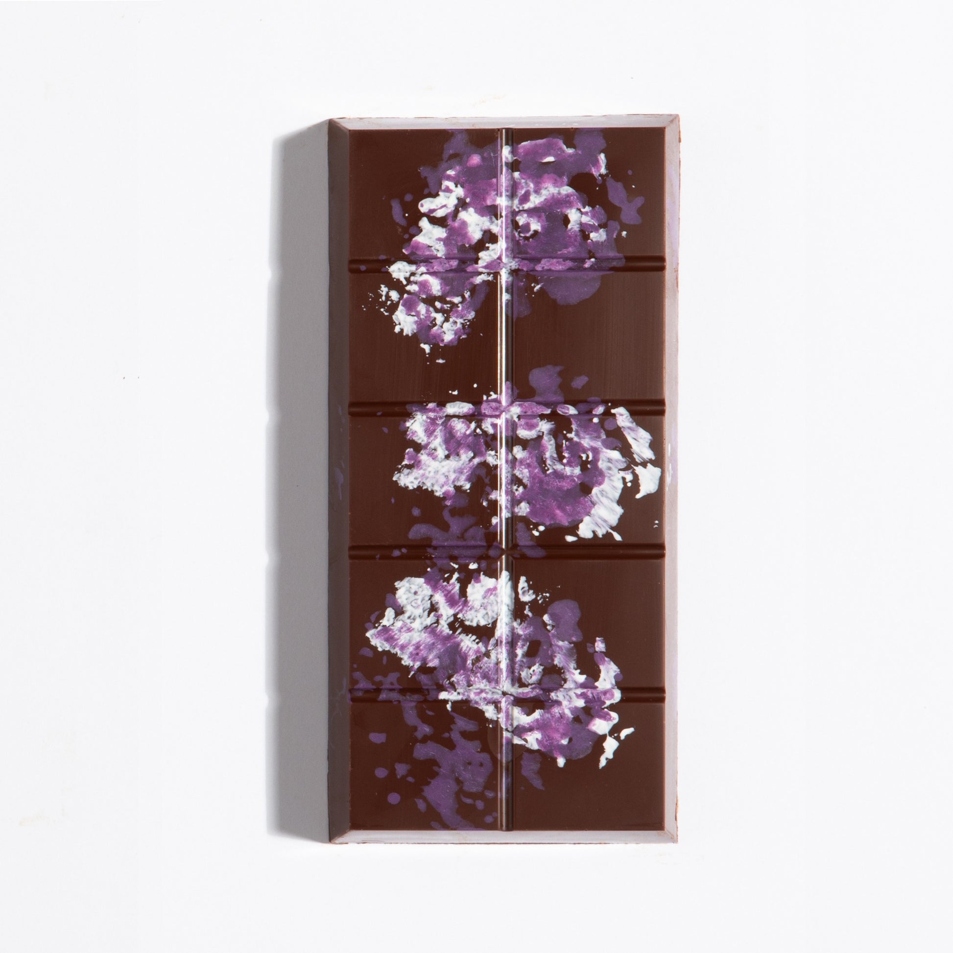 Unwrapped Peanut French Praline Crunch Bar with purple cocoa butter splatter on dark chocolate