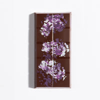 Unwrapped Peanut Praline Crunch Bar with purple cocoa butter splatter on dark chocolate