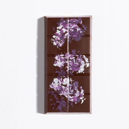 Unwrapped Peanut French Praline Crunch Bar with purple cocoa butter splatter on dark chocolate